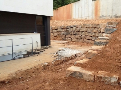 Trabajo de construcción de muro de piedra natural realizado por EXCAVACIONES JODAR para CLIENTE PARTICULAR